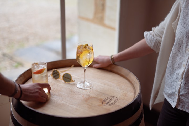 Deux cocktails au vin du domaine Guiraud posés sur une barrique en bois pour Château Guiraud à Sauternes.